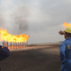 Iraqi Southern Oil Company engineers look towards the gas flares in the Zubair oil field in southern Iraq.